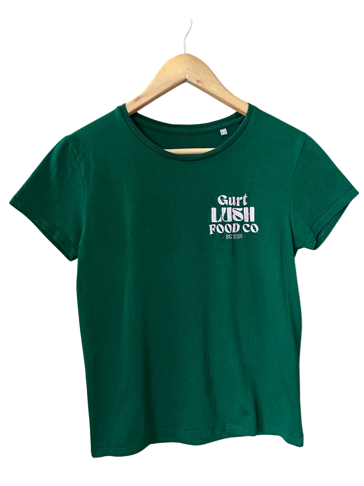 Green t-shirt with 'Surf Lush Food Co' text on a hanger against a white background