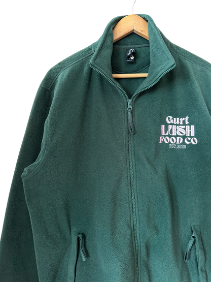 Green fleece vest with 'Gurt Wish Food Co' logo on a hanger against a white background