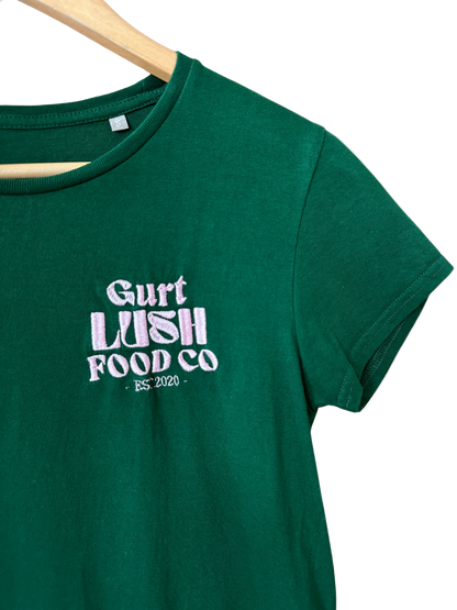 Green t-shirt with 'Gurt Lush Food Co' text on a wooden hanger