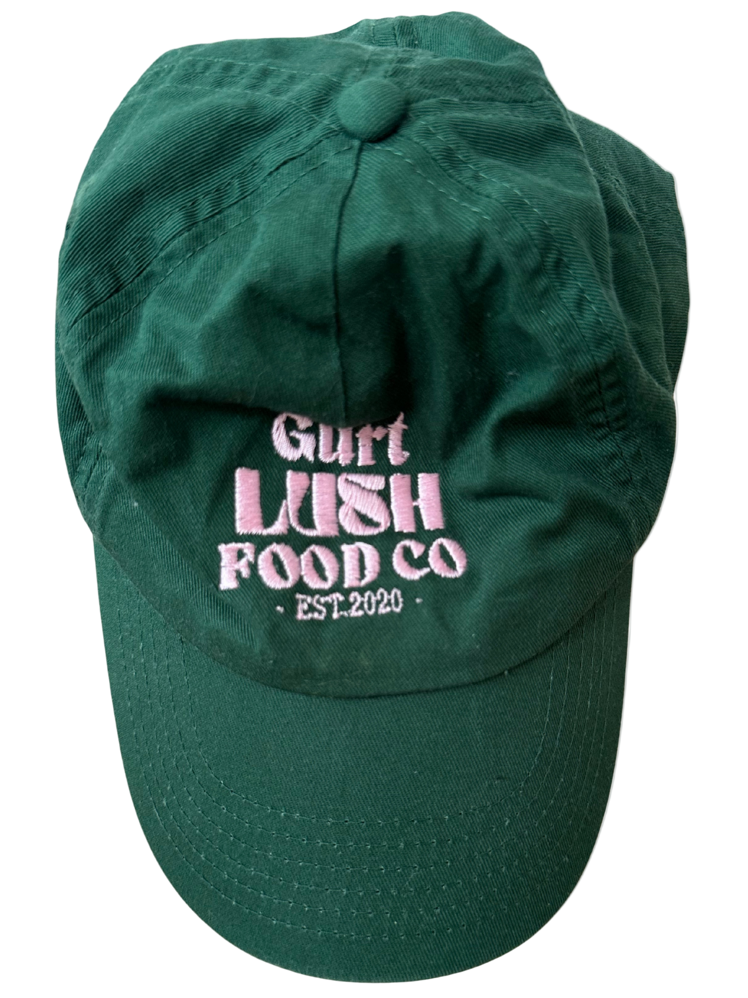 Green cap with pink text 'Gurt Lush Food Co. Est. 2020' on a white background